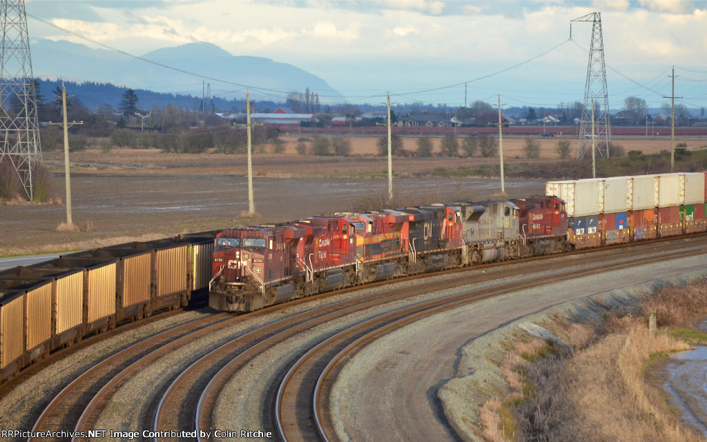 CP 8793/8066/KCS 4703/CN 3859/CP 7023/8101 pulling 11,740ft stack train to a slow entering Roberts Bank, passing an outbound empty BNSF coal train.